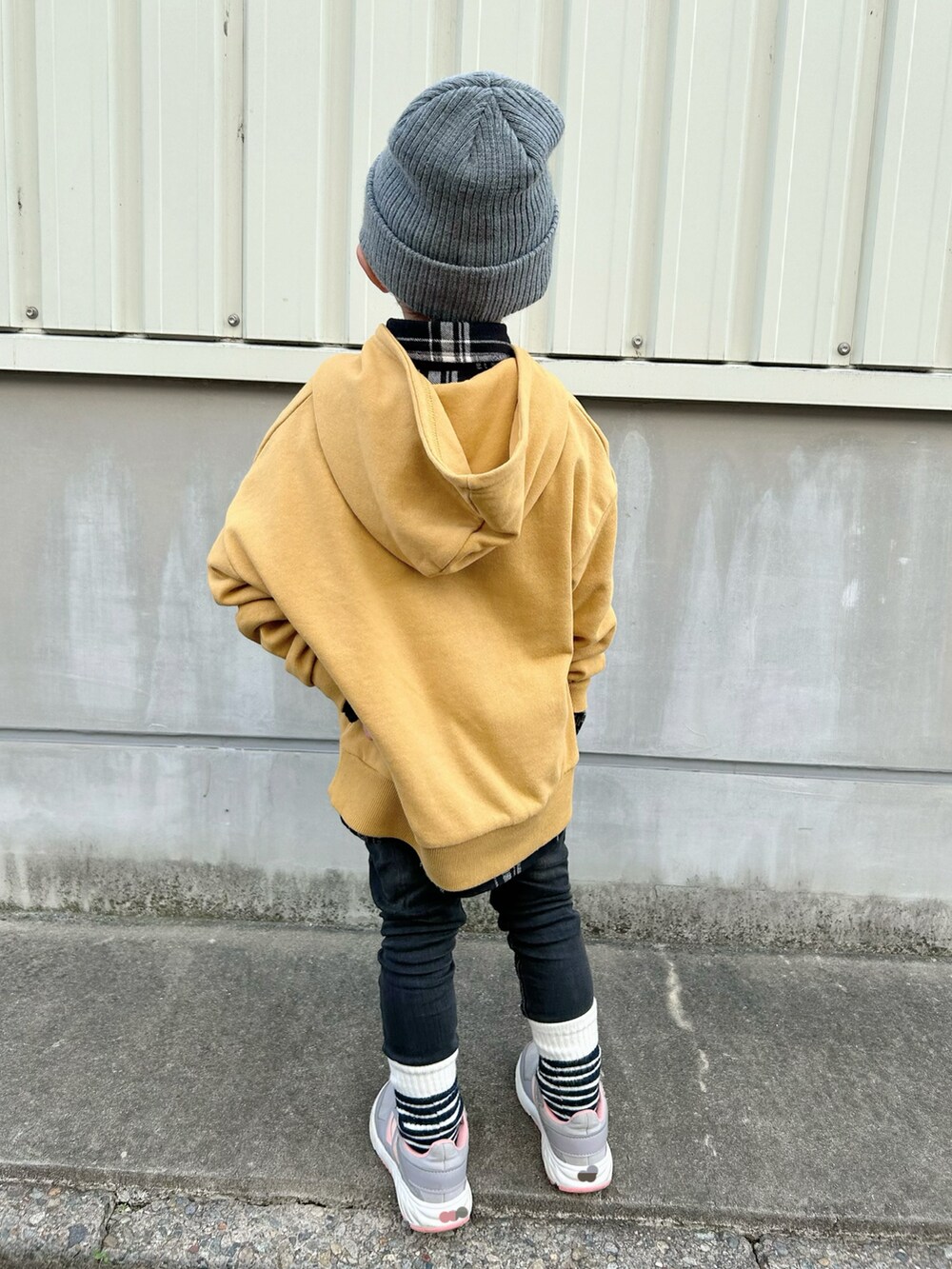 ブラック系のシャツ/ブラウス、イエロー系のパーカー、ブラック系のデニムパンツを着用したキッズの冬コーディネートの5枚目の写真