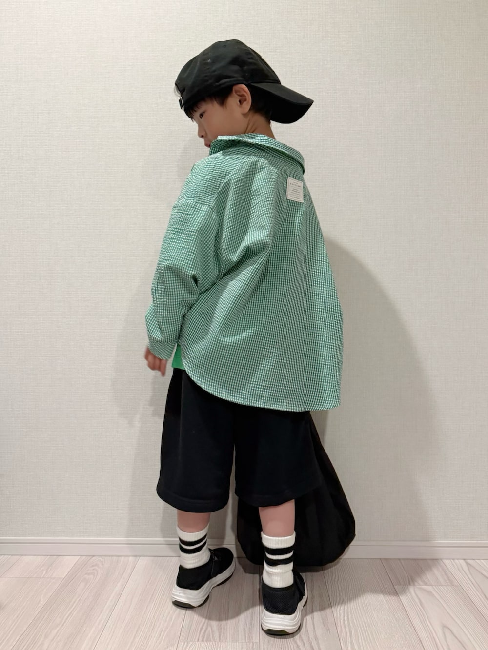 グリーン系のTシャツ/カットソー、ブラック系のセットアップ、ブラック系のサンダルを着用したキッズの春コーディネートの5枚目の写真