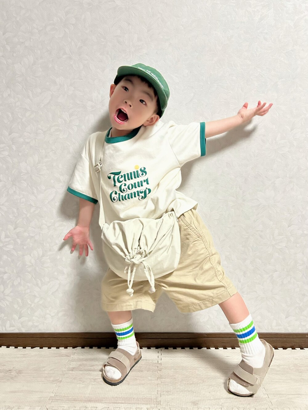 ホワイト系のTシャツ/カットソー、ホワイト系のショルダーバッグ、ベージュ系のチノパンツを着用したキッズの春コーディネートの3枚目の写真