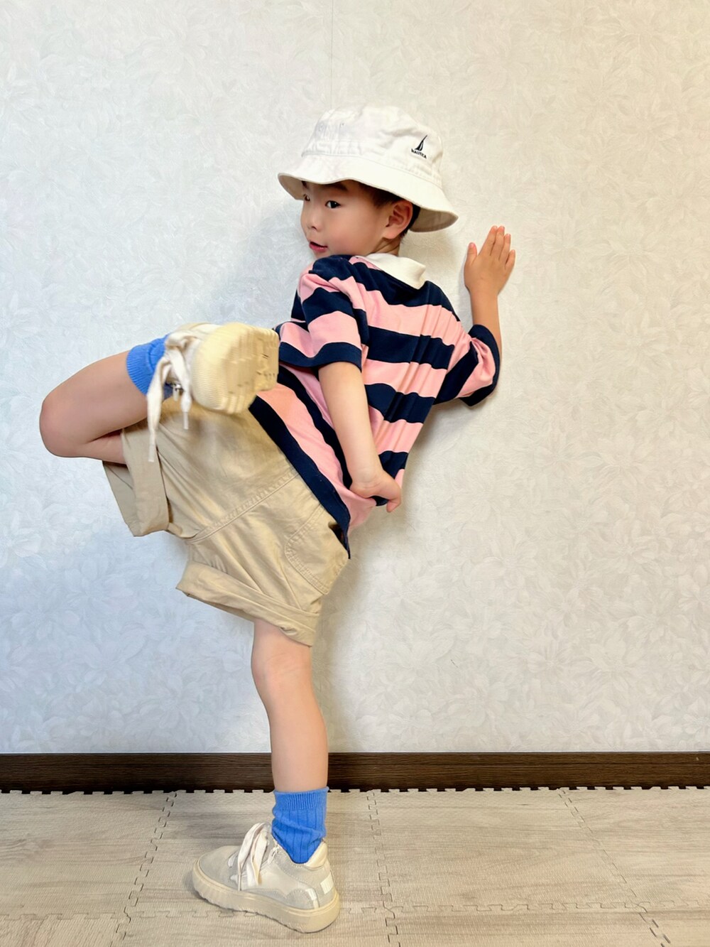 ピンク系のポロシャツ、ベージュ系のチノパンツ、ホワイト系のスニーカーを着用したキッズの春コーディネートの4枚目の写真