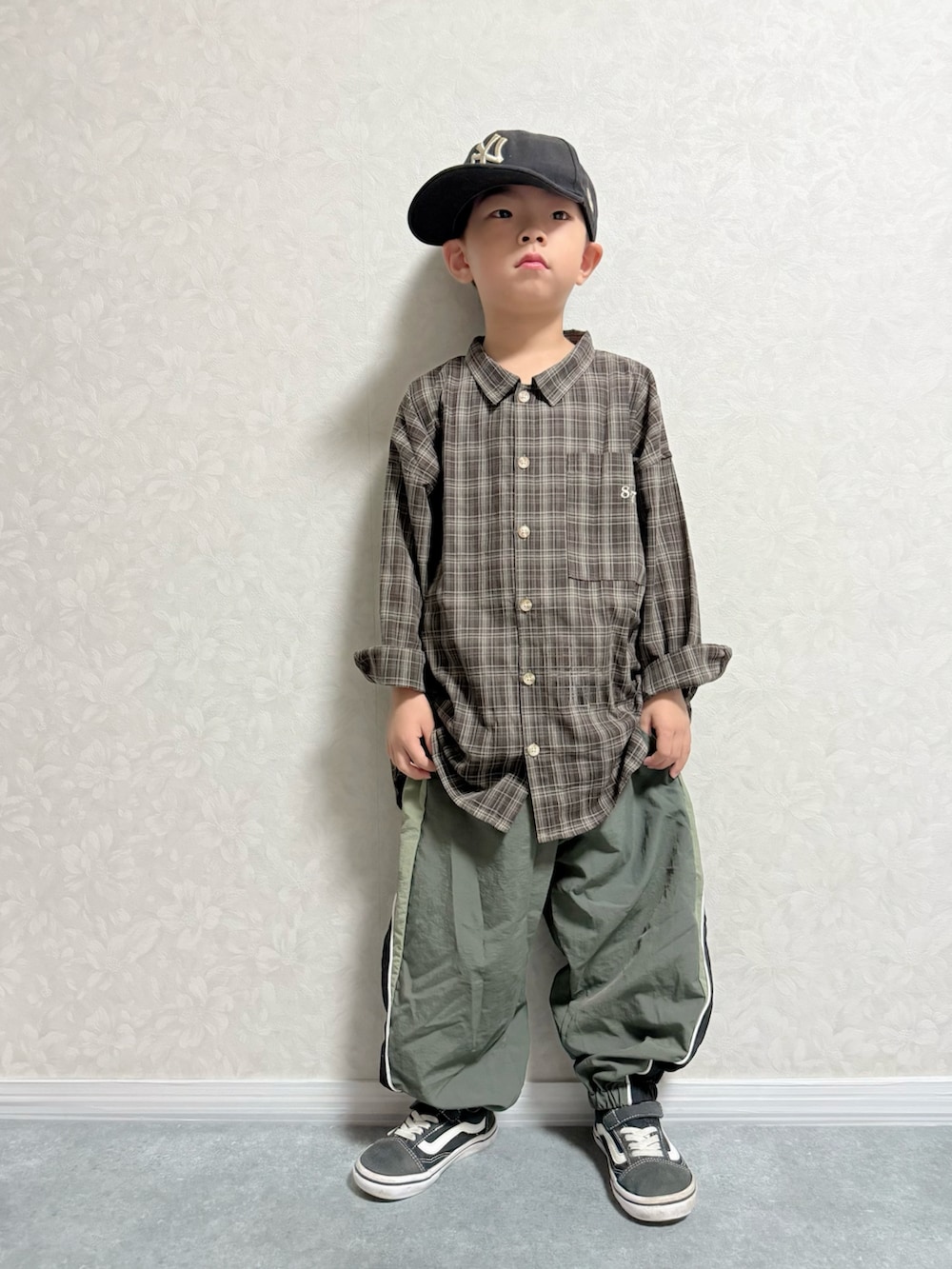 ブラウン系のシャツ/ブラウス、グリーン系のその他パンツ、ブラック系のスニーカーを着用したキッズの秋コーディネートの2枚目の写真