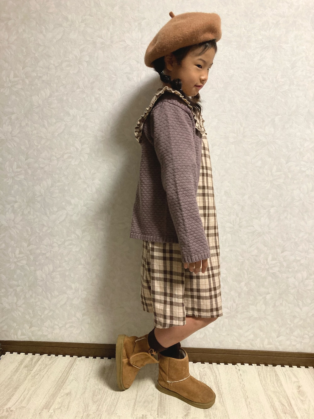 ブラウン系のシャツワンピース、グレー系のカーディガン/ボレロ、ベージュ系のブーツを着用したキッズの秋コーディネートの3枚目の写真