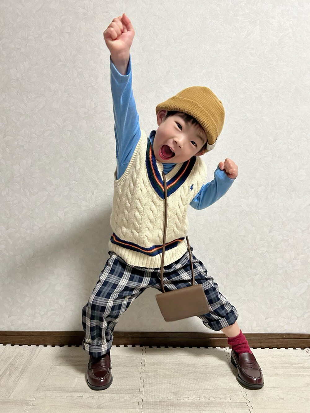ブルー系のTシャツ/カットソー、ホワイト系のベスト、ブラウン系のショルダーバッグを着用したキッズの冬コーディネートの4枚目の写真