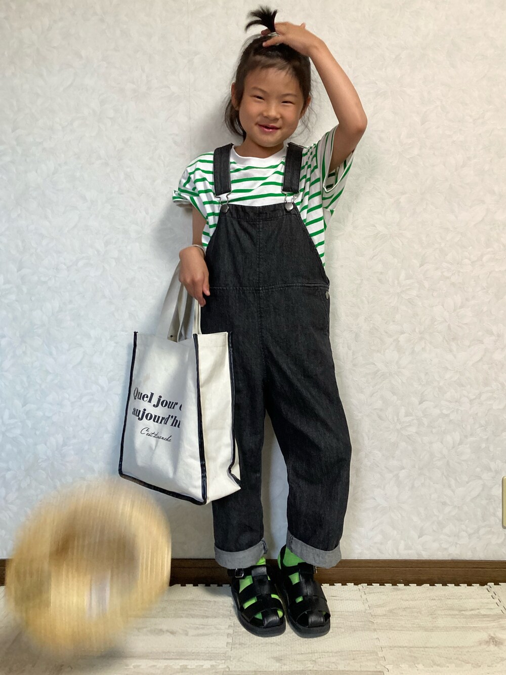 グリーン系のTシャツ/カットソー、ホワイト系のトートバッグ、ブラック系のサロペット/オーバーオールを着用したキッズの春コーディネートの2枚目の写真