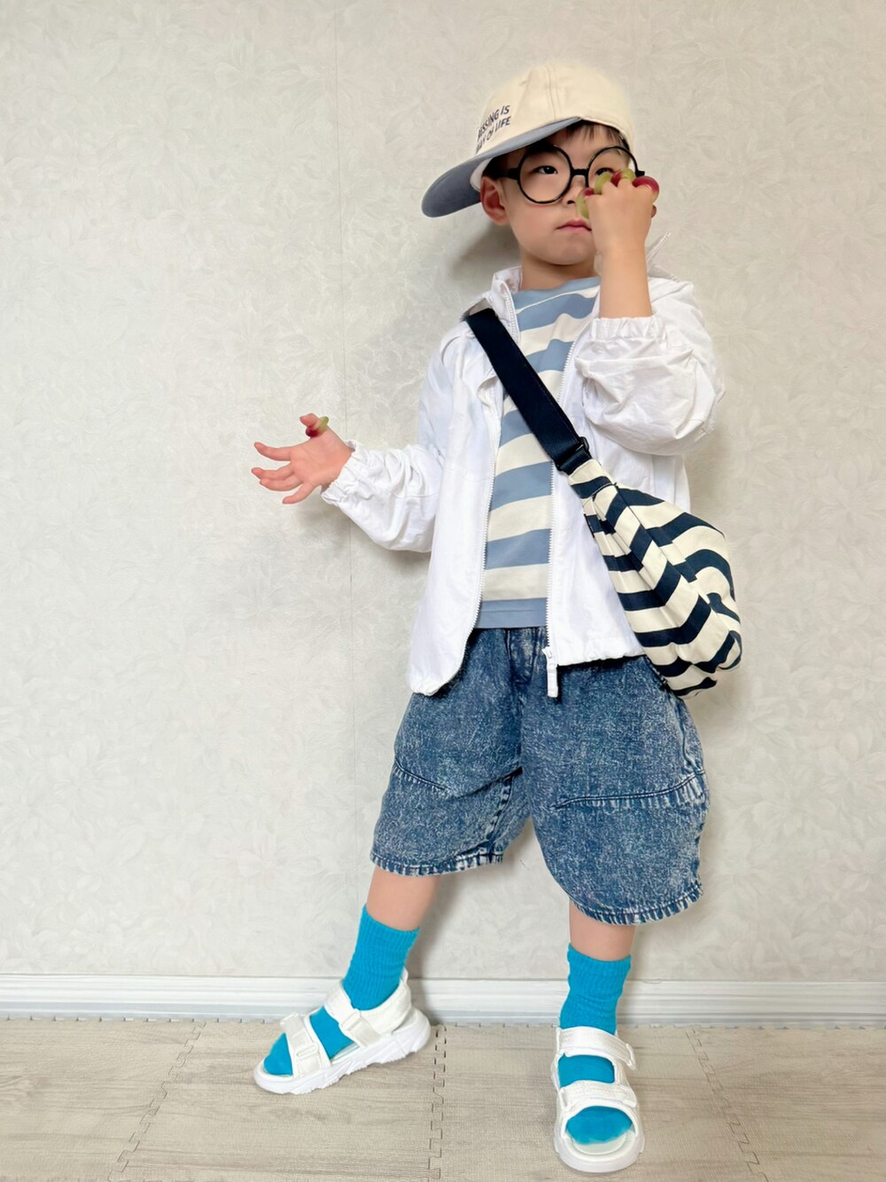 ブルー系のTシャツ/カットソー、ホワイト系のナイロンジャケット、ホワイト系のショルダーバッグを着用したキッズの春コーディネートの2枚目の写真