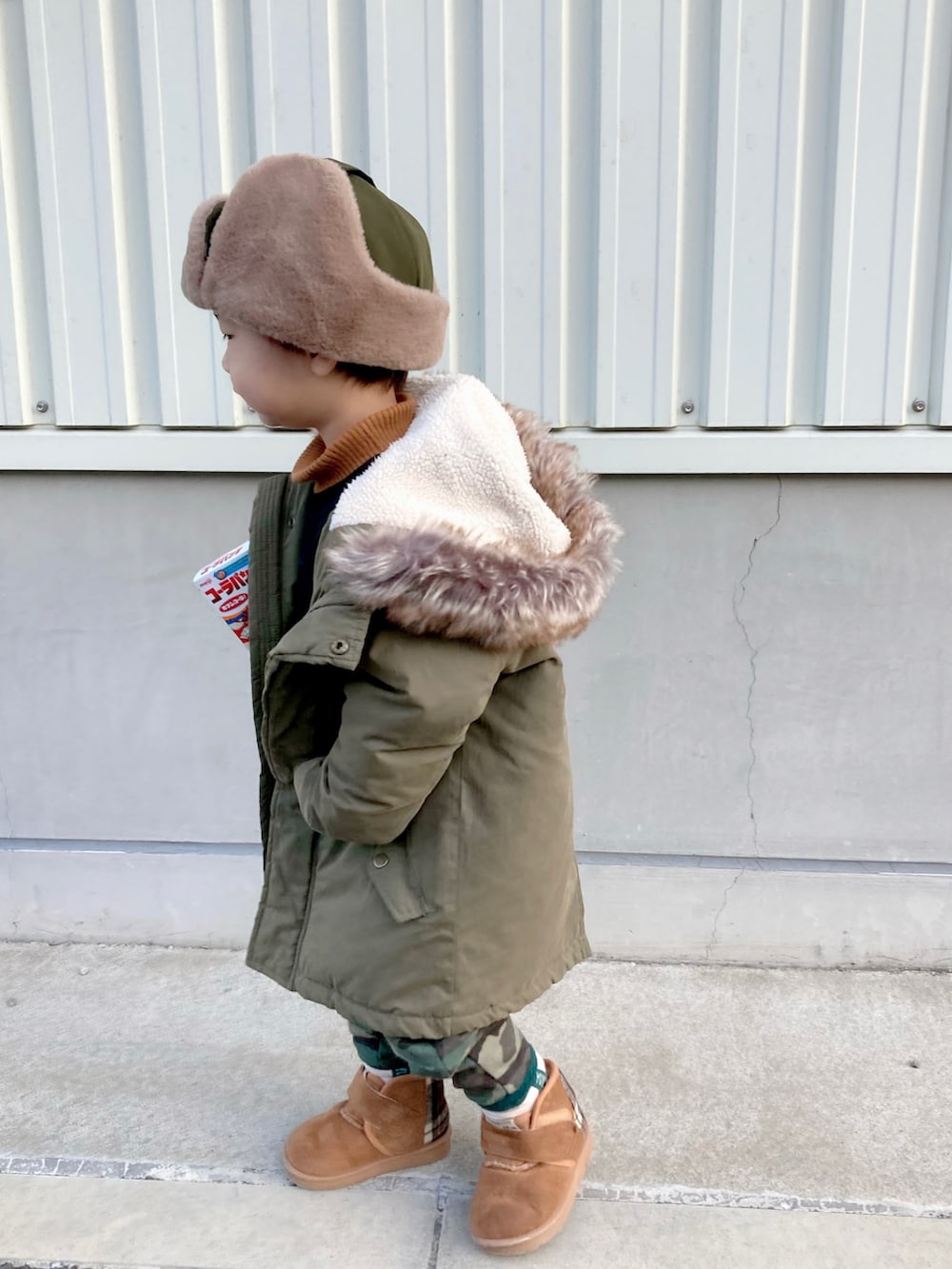 イエロー系のニット/セーター、ブラック系のTシャツ/カットソー、グリーン系のモッズコートを着用したキッズの冬コーディネートの4枚目の写真