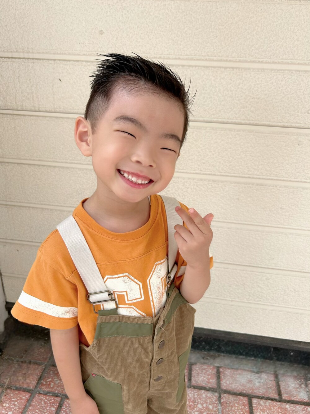 オレンジ系のTシャツ/カットソー、グリーン系のサロペット/オーバーオール、その他のスリッポンを着用したキッズの秋コーディネートの4枚目の写真