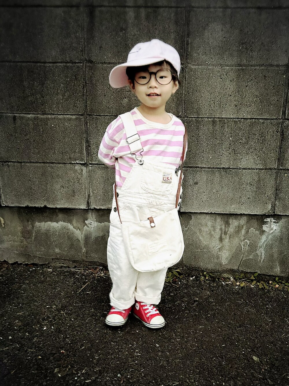 ピンク系のTシャツ/カットソー、ホワイト系のサロペット/オーバーオール、ホワイト系のショルダーバッグを着用したキッズの春コーディネートの2枚目の写真