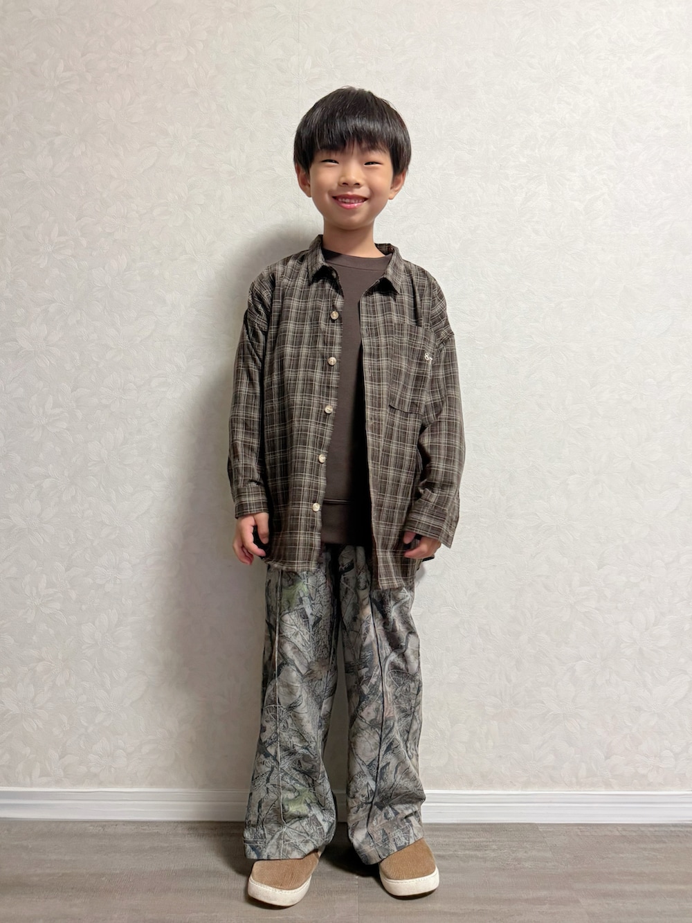 ブラウン系のシャツ/ブラウス、ベージュ系のその他パンツ、ブラウン系のスリッポンを着用したキッズの秋コーディネートの3枚目の写真