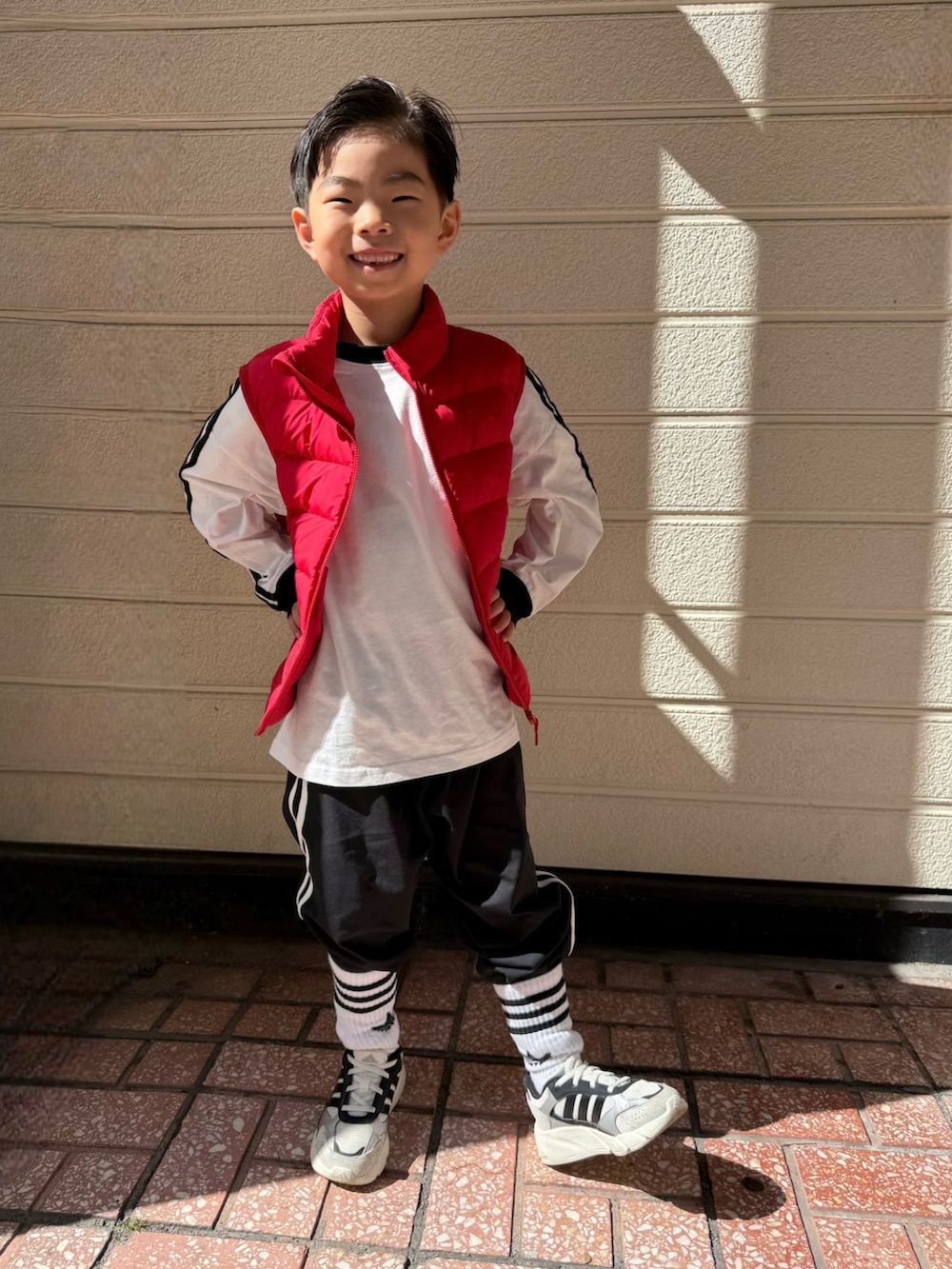 ホワイト系のTシャツ/カットソー、ブラック系のその他パンツ、ホワイト系のスニーカーを着用したキッズの春コーディネートの4枚目の写真