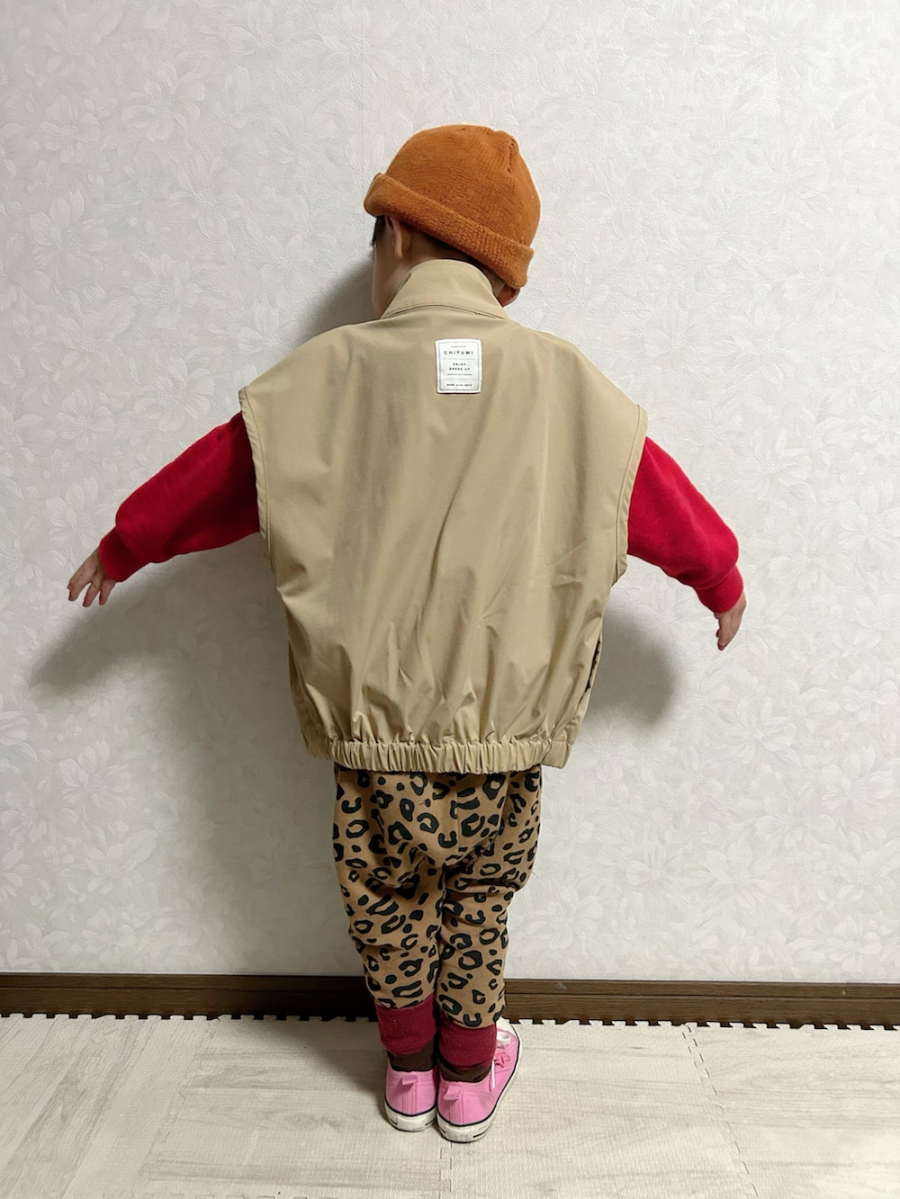 ベージュ系のベスト、レッド系のスウェット、ブラウン系のスウェットパンツを着用したキッズの冬コーディネートの4枚目の写真