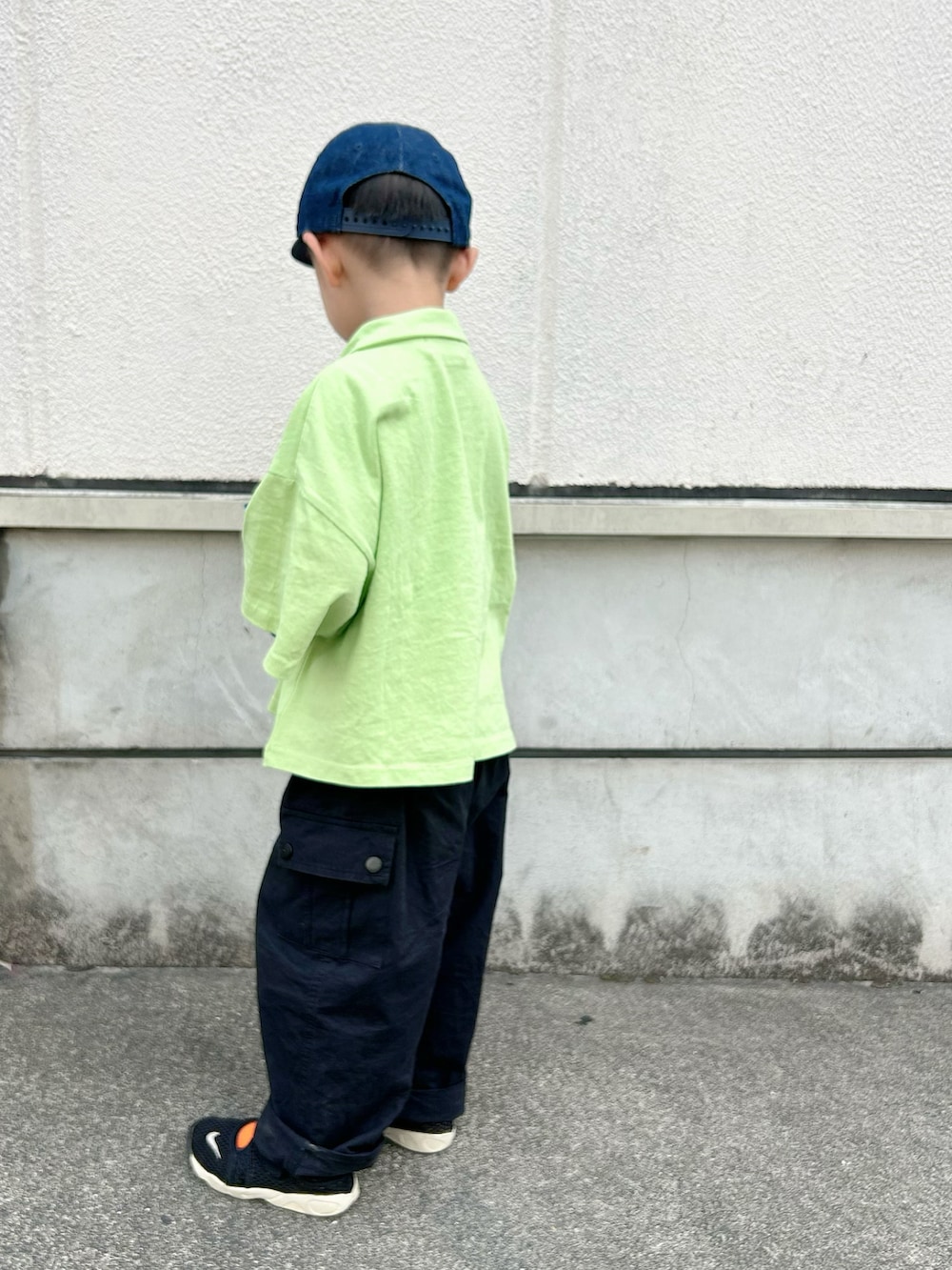 ブラック系のタンクトップ、グリーン系のポロシャツ、ブラック系のカーゴパンツを着用したキッズの春コーディネートの4枚目の写真
