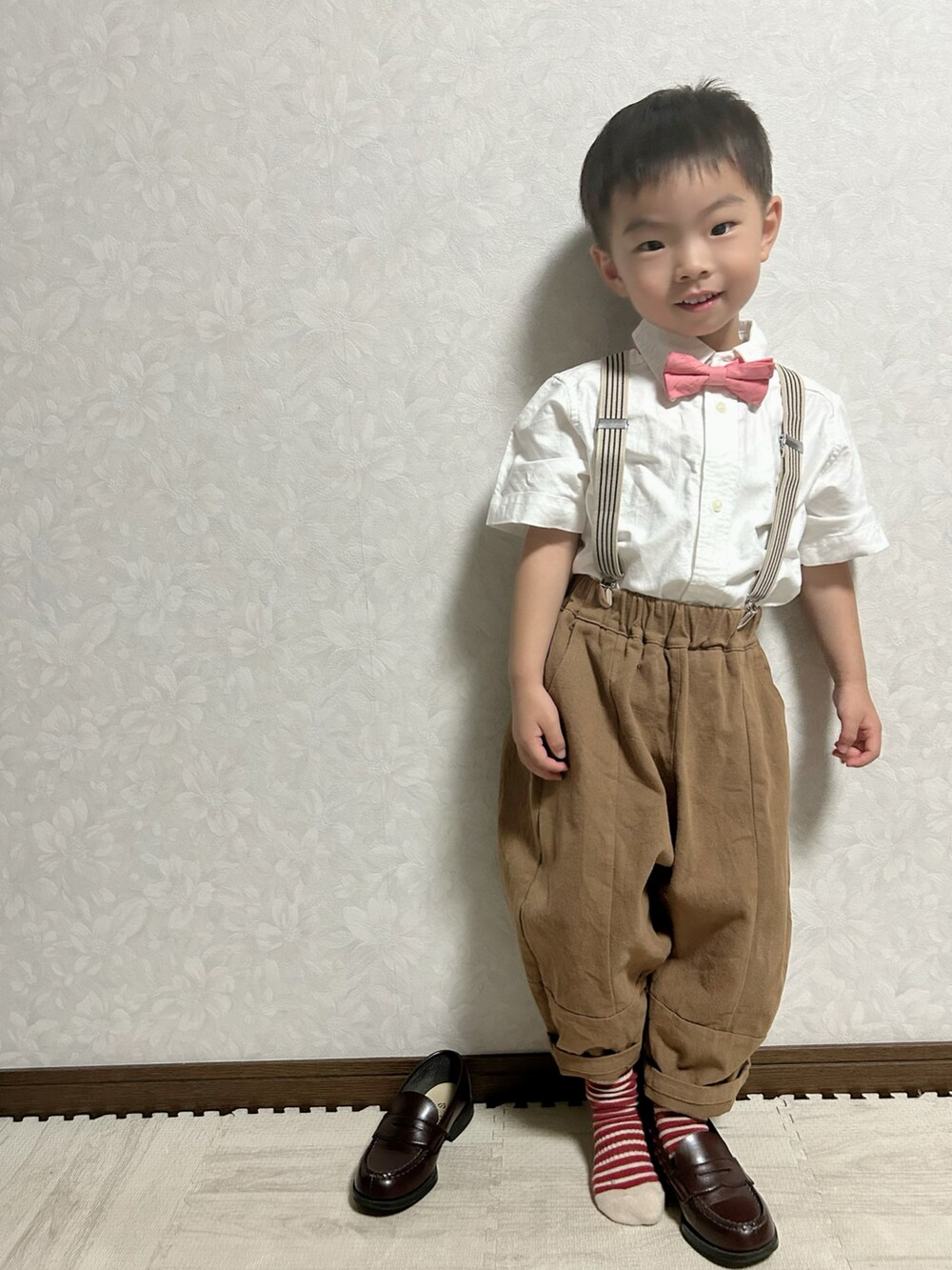 ホワイト系のシャツ/ブラウス、ベージュ系のトレンチコート、ブラウン系のチノパンツを着用したキッズの秋コーディネートの4枚目の写真