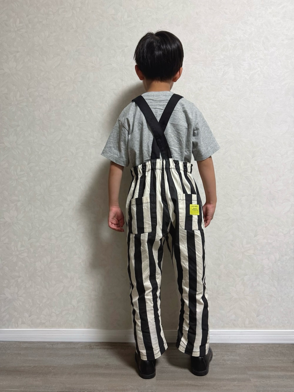 ブラック系のサロペット/オーバーオール、ブラック系のローファー、グレー系のTシャツ/カットソーを着用したキッズの夏コーディネートの2枚目の写真