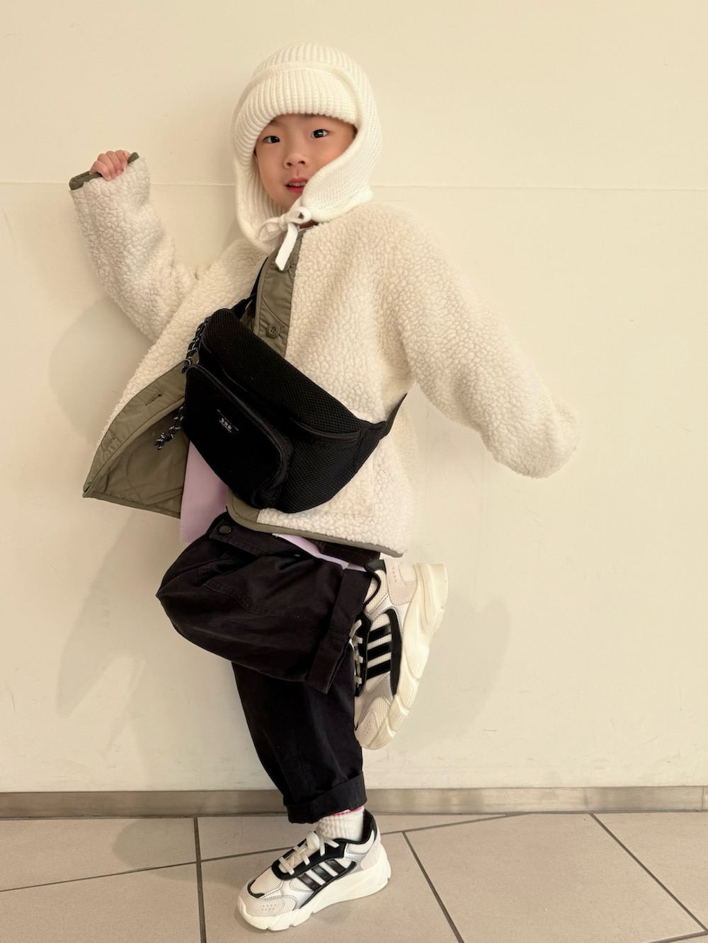 パープル系のTシャツ/カットソー、グリーン系のノーカラージャケット、ブラック系のボディバッグ/ウエストポーチを着用したキッズの冬コーディネートの3枚目の写真