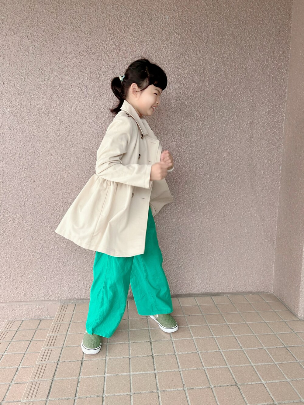 ブルー系のTシャツ/カットソー、ベージュ系のトレンチコート、グリーン系のパンツを着用したキッズの春コーディネートの5枚目の写真