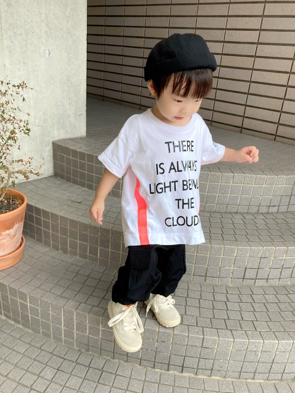 ホワイト系のTシャツ/カットソー、ブラック系のベスト、ブラック系のカーゴパンツを着用したキッズの秋コーディネートの3枚目の写真