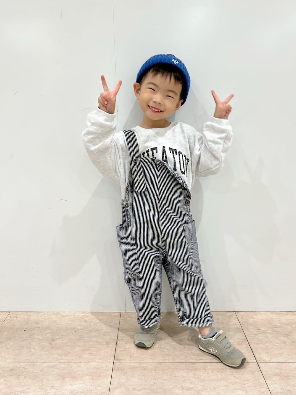 グレー系のスウェット、ブラック系のカーディガン/ボレロ、ホワイト系のショルダーバッグを着用したキッズの秋コーディネートの3枚目の写真