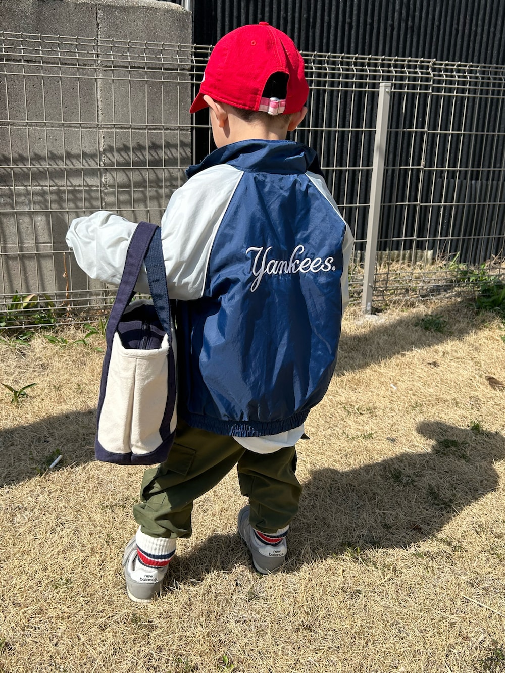 ブルー系のナイロンジャケット、ホワイト系のシャツ/ブラウス、ホワイト系のスウェットを着用したキッズの春コーディネートの5枚目の写真