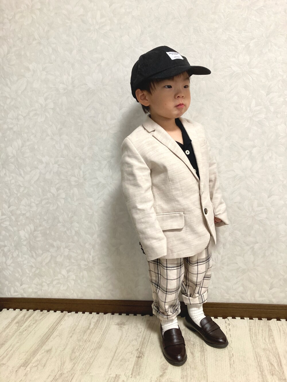 ブラック系のシャツ/ブラウス、ベージュ系のテーラードジャケット、ホワイト系のパンツを着用したキッズの春コーディネートの2枚目の写真