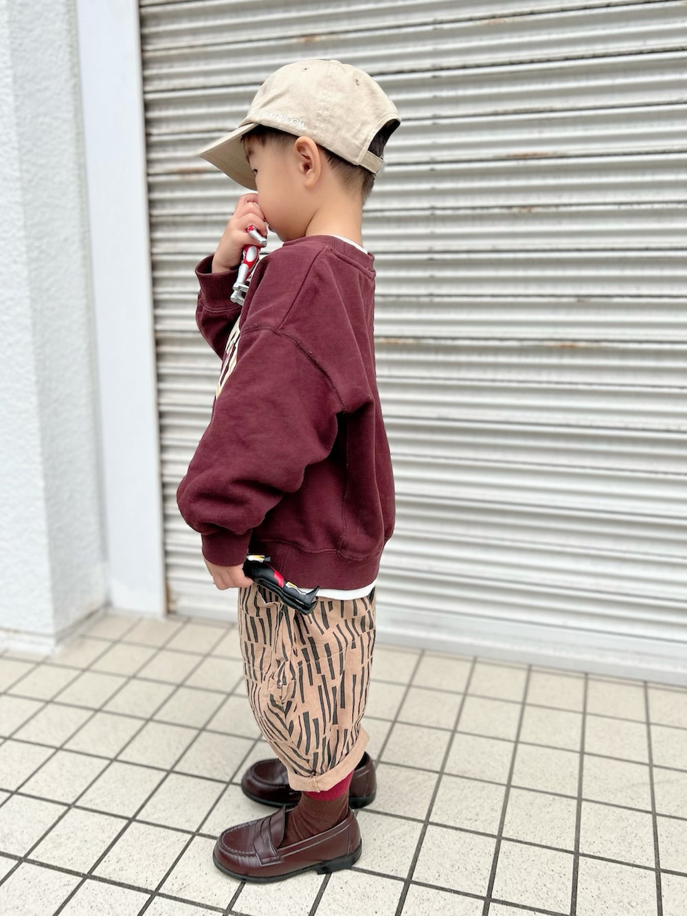 ブラウン系のスウェット、ブラウン系のパンツ、ホワイト系のスニーカーを着用したキッズの秋コーディネートの5枚目の写真