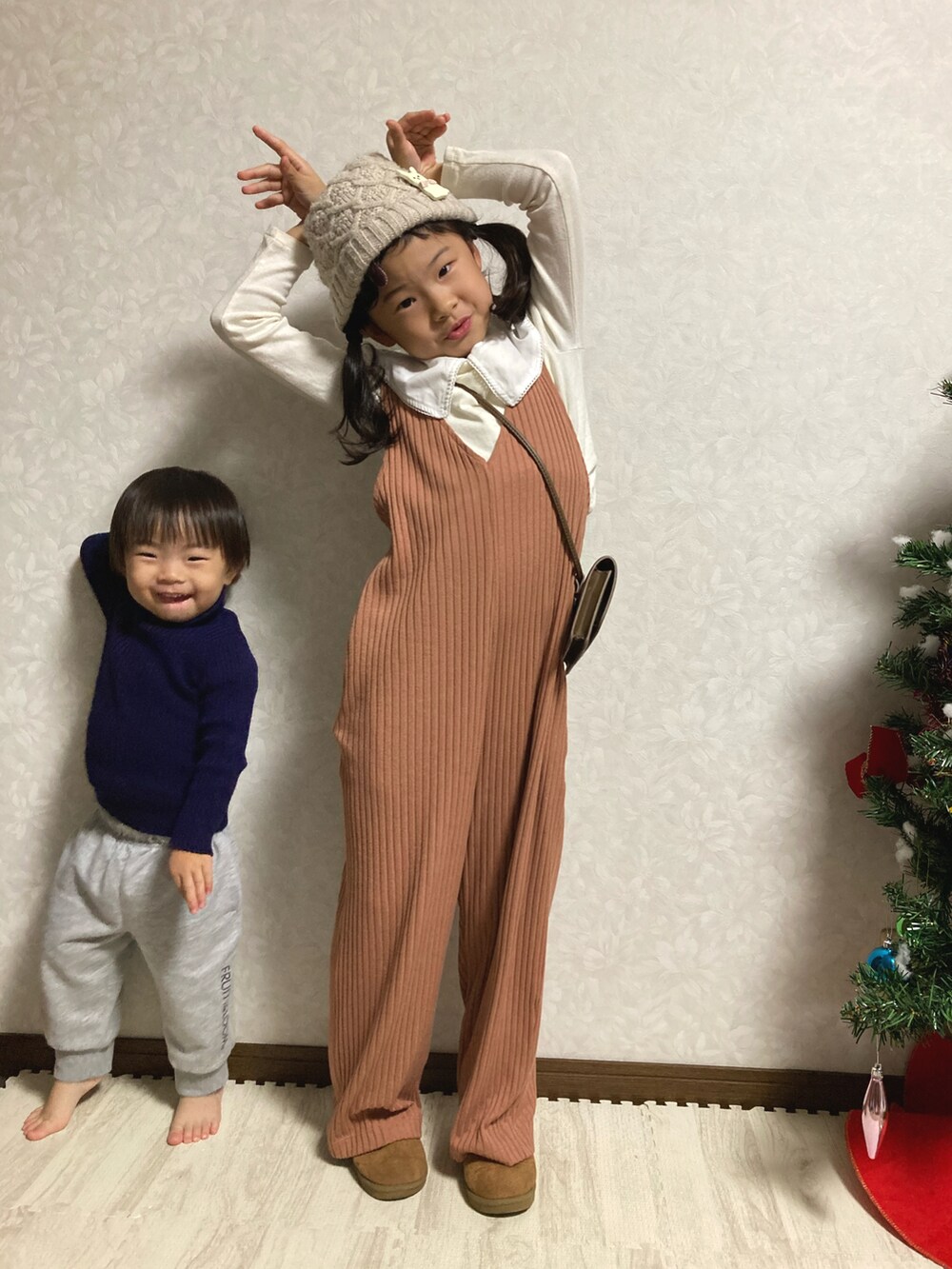 ホワイト系のTシャツ/カットソー、オレンジ系のサロペット/オーバーオール、ベージュ系のブーツを着用したキッズの冬コーディネートの5枚目の写真