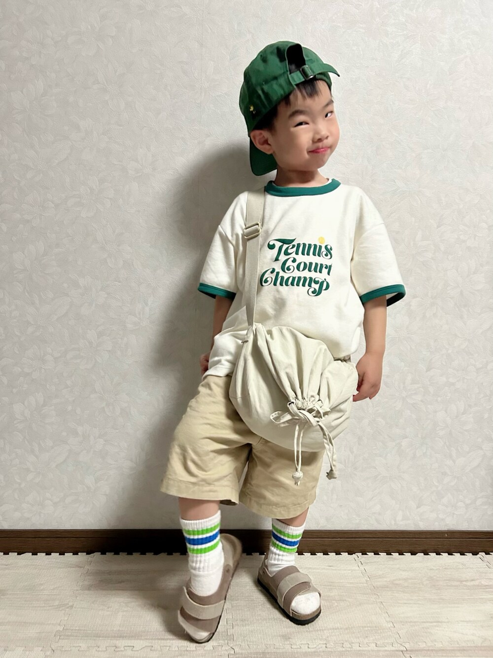 ホワイト系のTシャツ/カットソー、ホワイト系のショルダーバッグ、ベージュ系のチノパンツを着用したキッズの春コーディネートの4枚目の写真