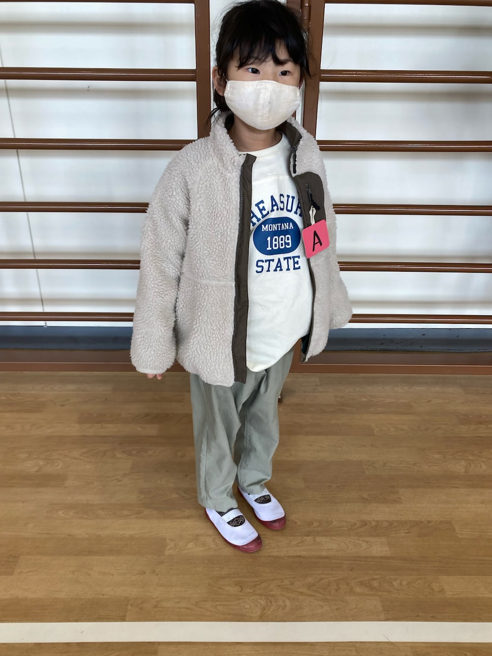 レッド系のTシャツ/カットソー、ホワイト系のTシャツ/カットソー、ベージュ系のジャケット/アウターを着用したキッズの冬コーディネートの2枚目の写真