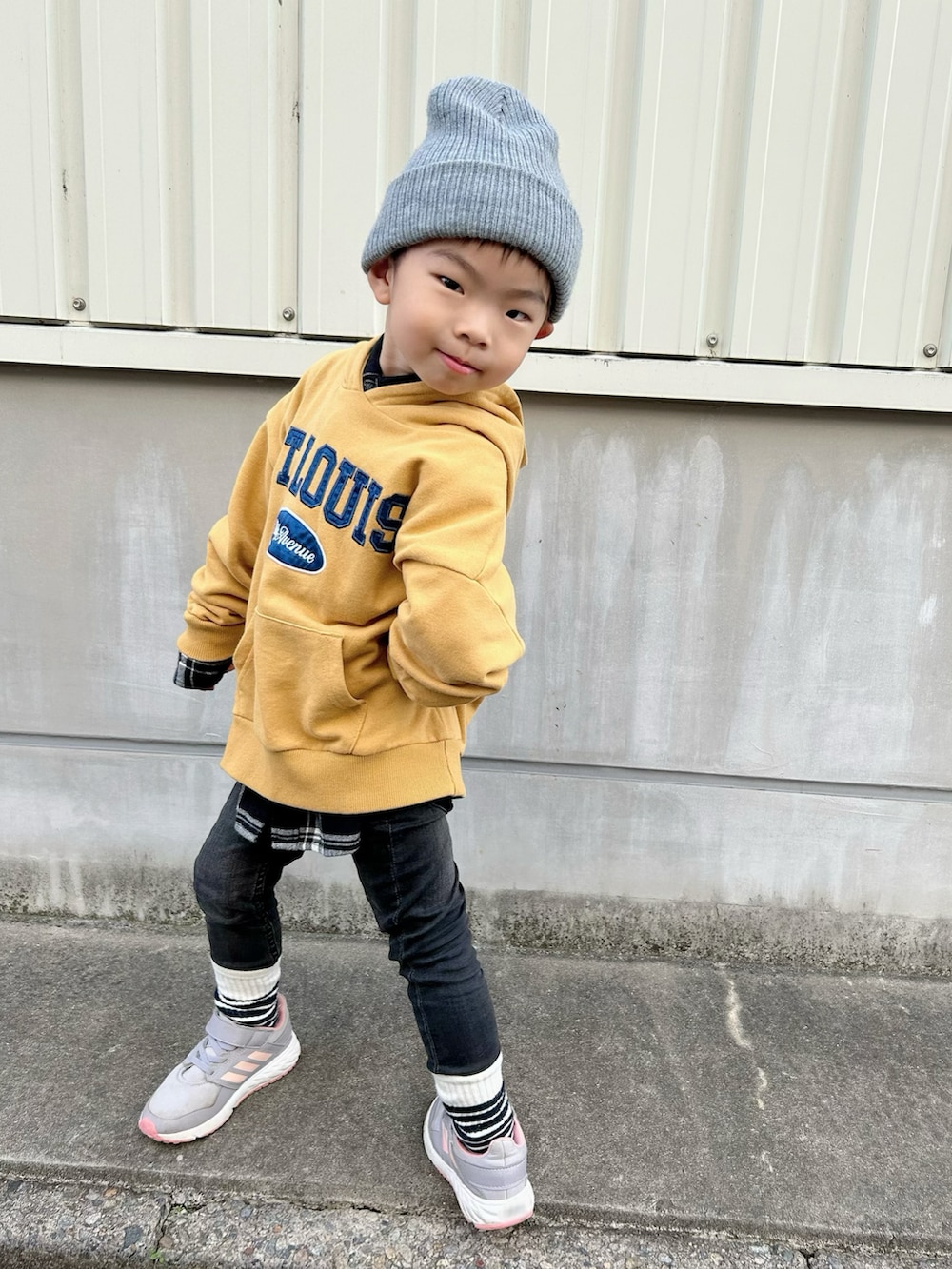 ブラック系のシャツ/ブラウス、イエロー系のパーカー、ブラック系のデニムパンツを着用したキッズの冬コーディネートの3枚目の写真