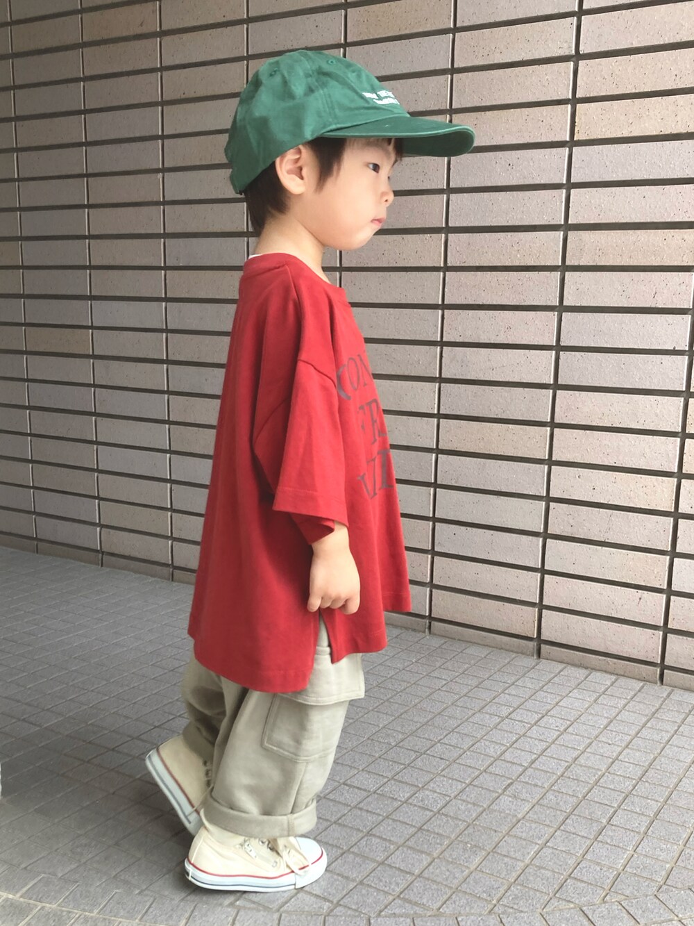 レッド系のTシャツ/カットソー、グリーン系のスウェットパンツ、グリーン系のキャップを着用したキッズの夏コーディネートの5枚目の写真