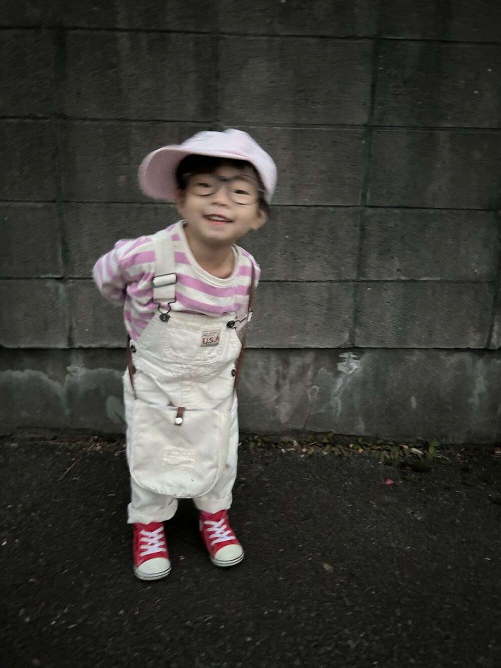 ピンク系のTシャツ/カットソー、ホワイト系のサロペット/オーバーオール、ホワイト系のショルダーバッグを着用したキッズの春コーディネートの4枚目の写真