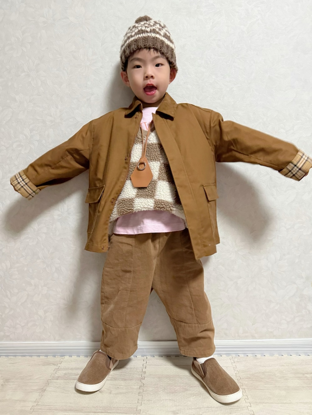 ブラウン系のブルゾン、ピンク系のTシャツ/カットソー、ブラウン系のベストを着用したキッズの冬コーディネートの2枚目の写真