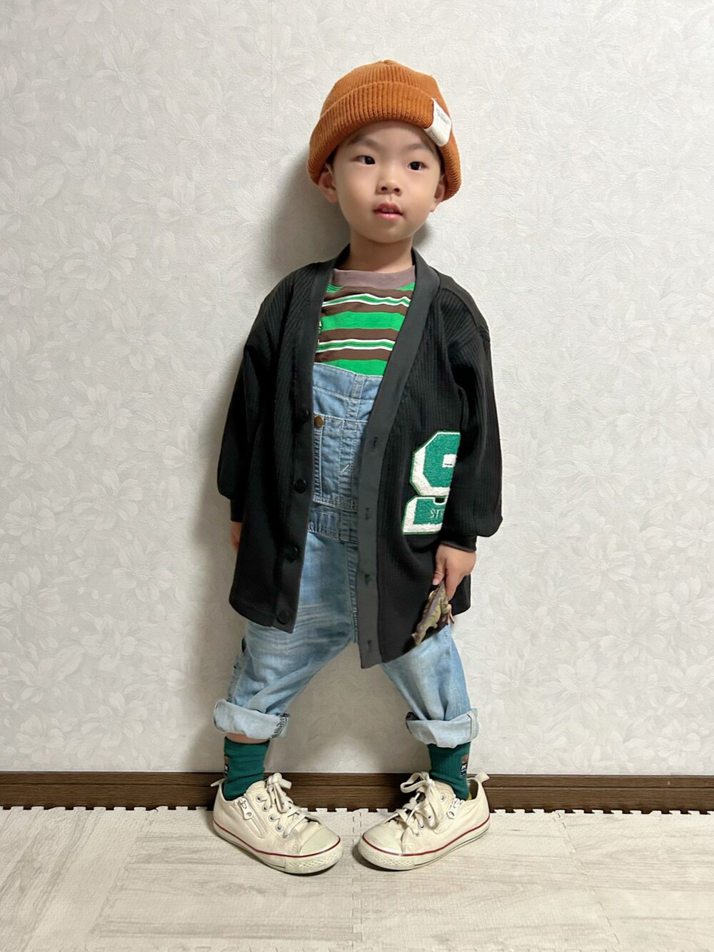 グリーン系のTシャツ/カットソー、ブラック系のカーディガン/ボレロ、ブルー系のサロペット/オーバーオールを着用したキッズの秋コーディネートの2枚目の写真