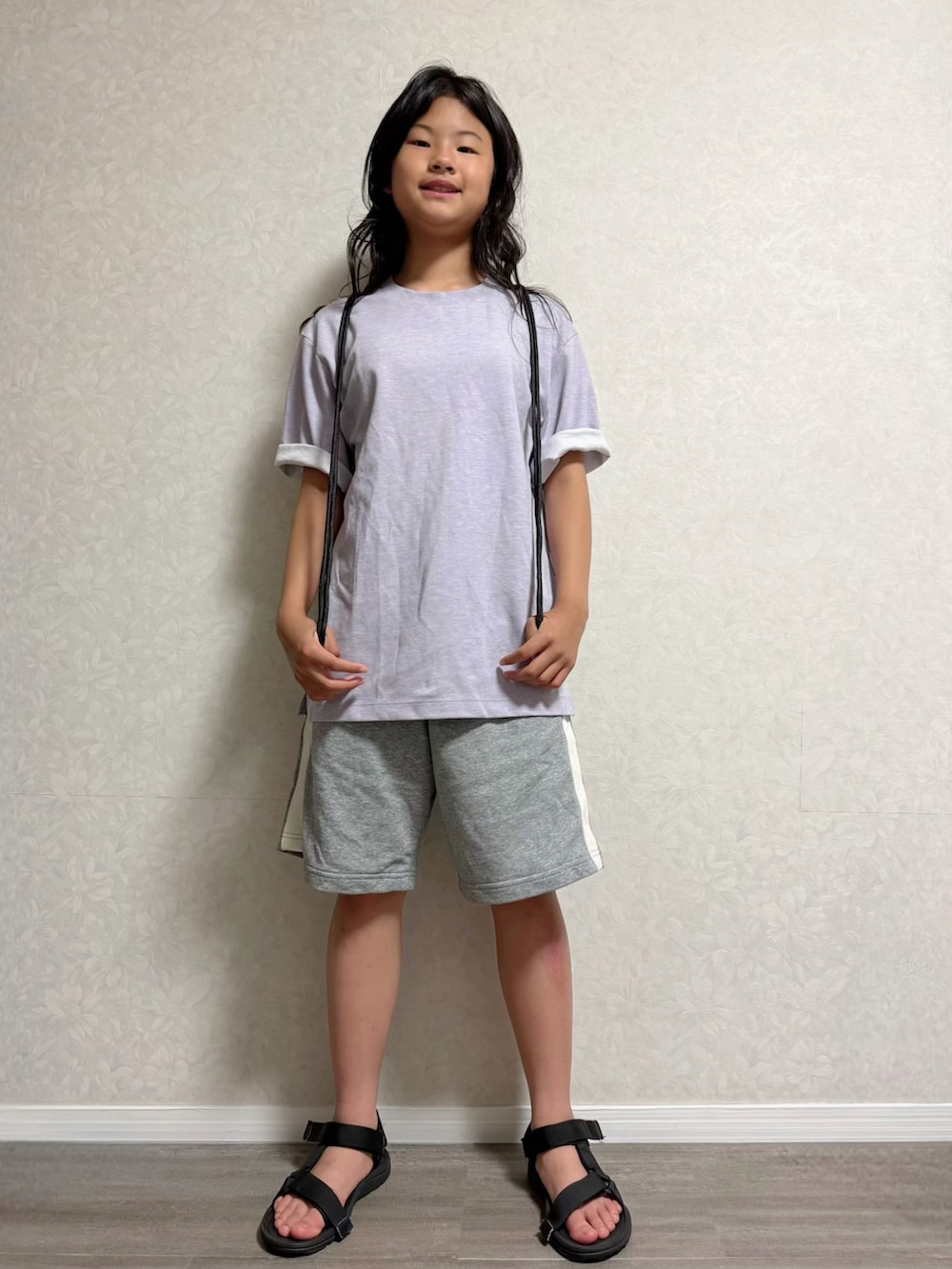 ブラック系のバックパック/リュック、ブラック系のサンダル、パープル系のTシャツ/カットソーを着用したキッズの夏コーディネートの3枚目の写真