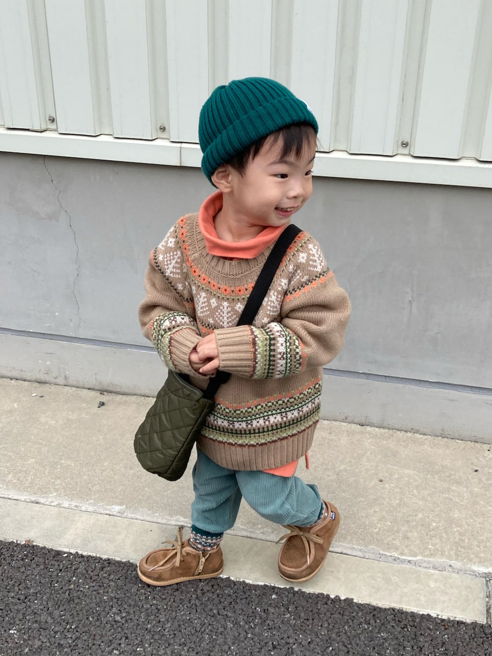 ベージュ系のニット/セーター、オレンジ系のスウェット、グリーン系のその他パンツを着用したキッズの秋コーディネートの2枚目の写真