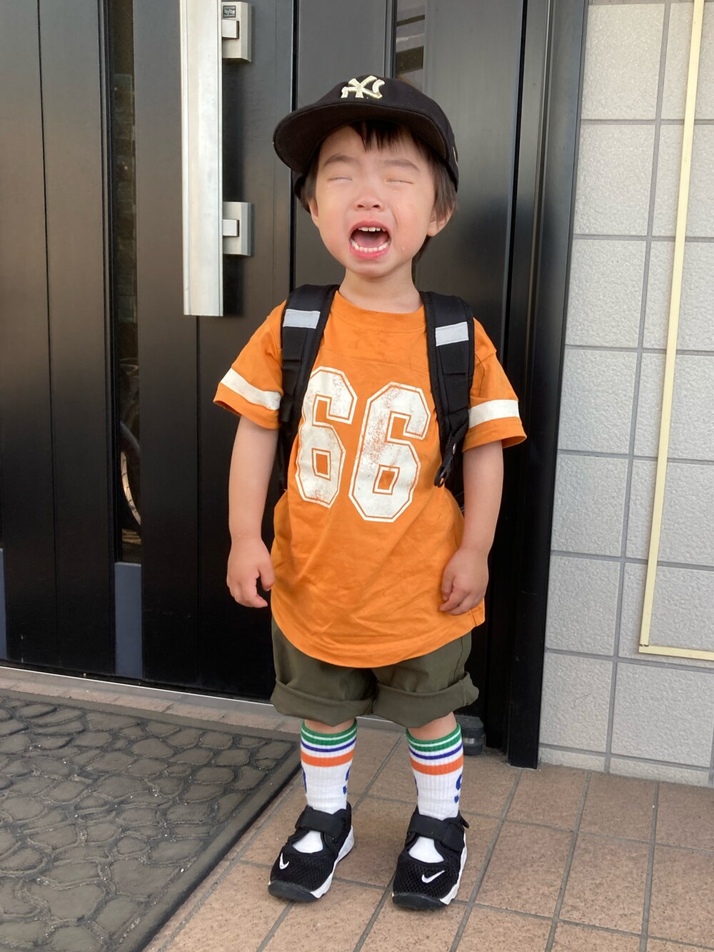 オレンジ系のTシャツ/カットソー、グリーン系のカーゴパンツ、ブラック系のスニーカーを着用したキッズの夏コーディネートの5枚目の写真