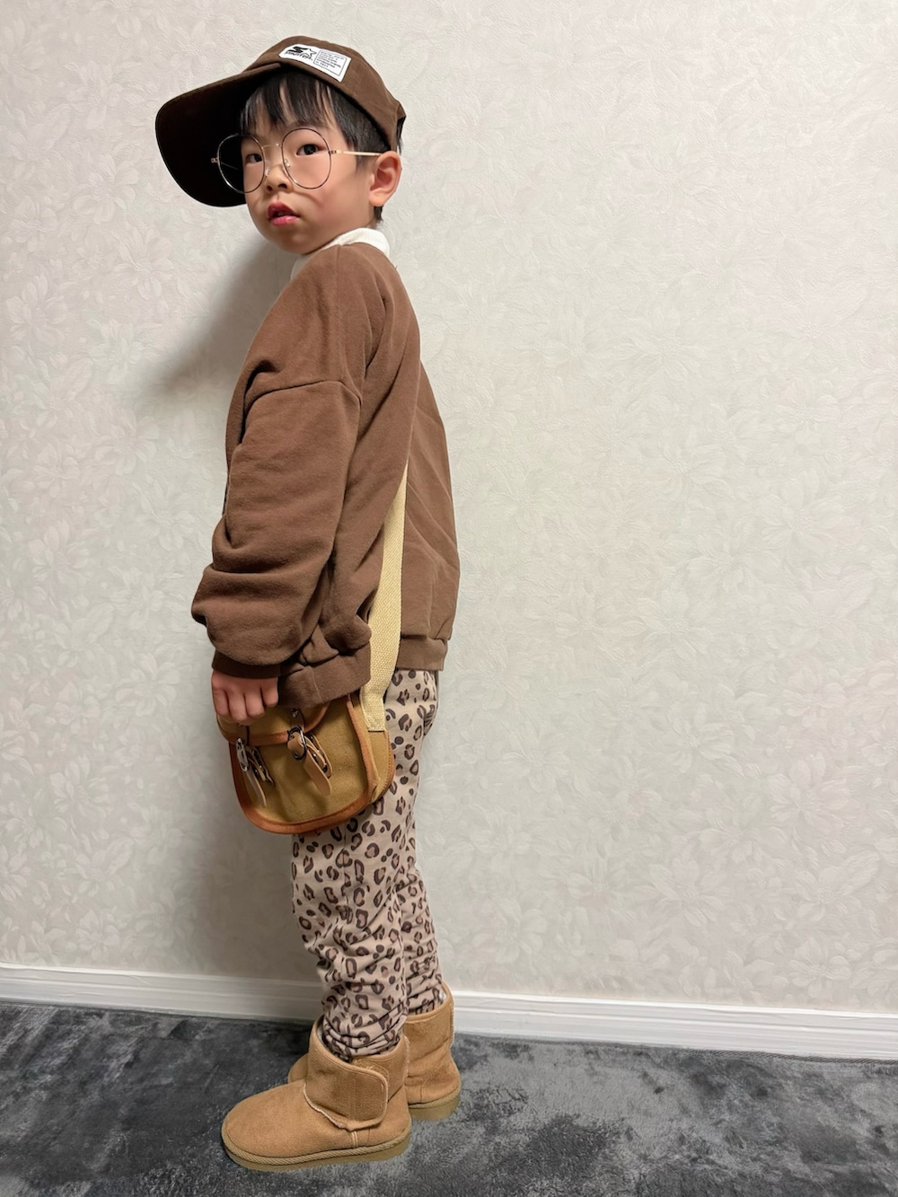 ブラウン系のその他パンツ、ブラウン系のショルダーバッグ、ホワイト系のTシャツ/カットソーを着用したキッズの冬コーディネートの4枚目の写真