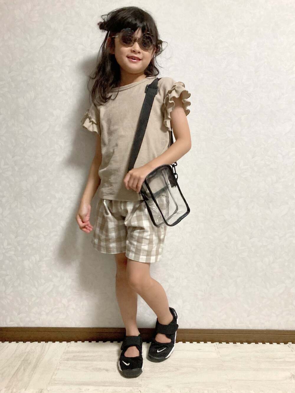 その他のショルダーバッグ、ブラック系のスニーカー、オレンジ系のサングラスを着用したキッズの夏コーディネートの2枚目の写真