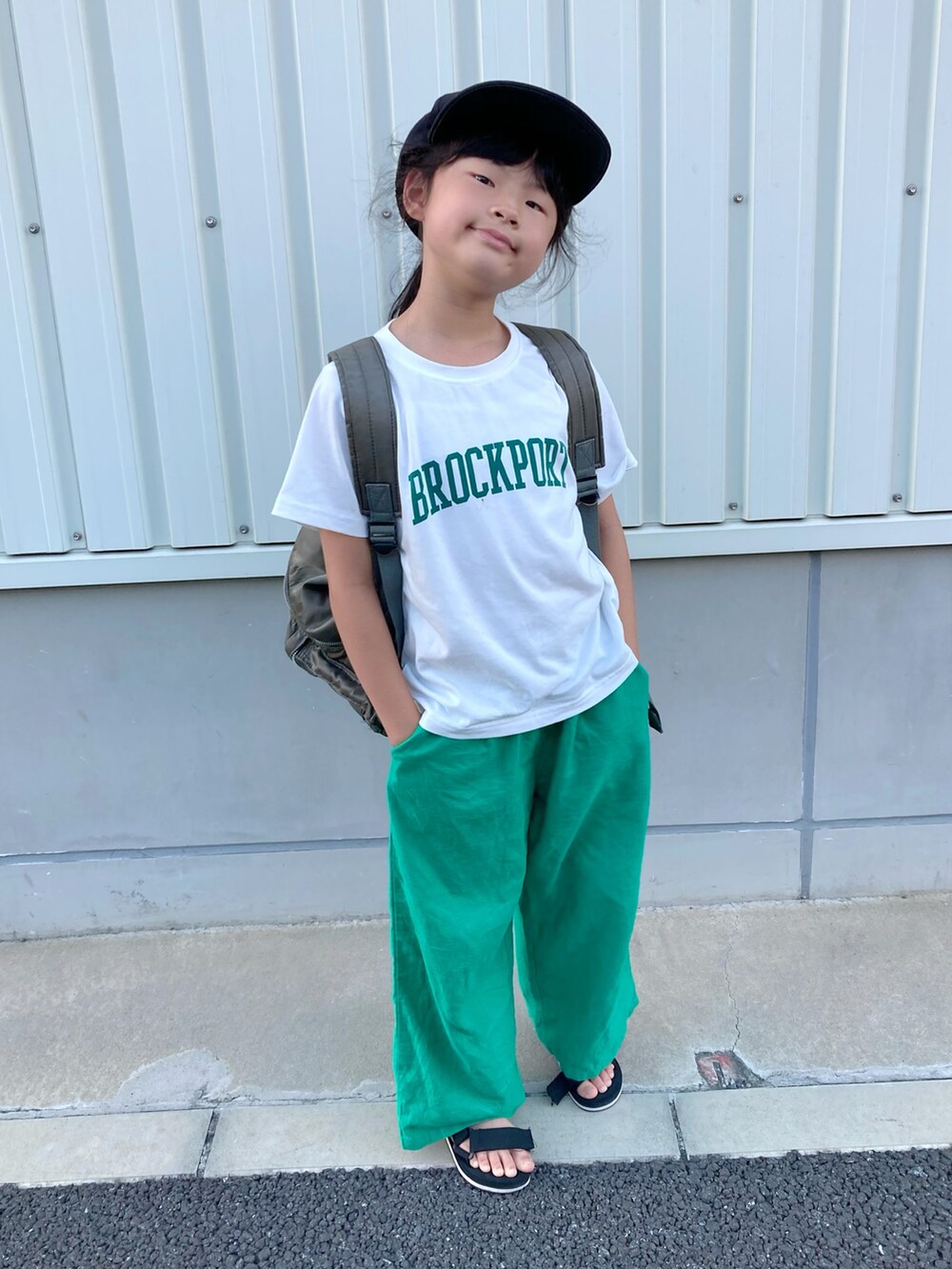 ホワイト系のTシャツ/カットソー、グレー系のバックパック/リュック、グリーン系のパンツを着用したキッズの夏コーディネートの2枚目の写真