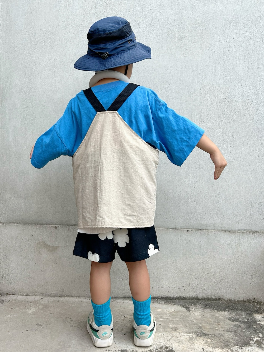 ブルー系のTシャツ/カットソー、ホワイト系のニット/セーター、ベージュ系のベストを着用したキッズの夏コーディネートの3枚目の写真