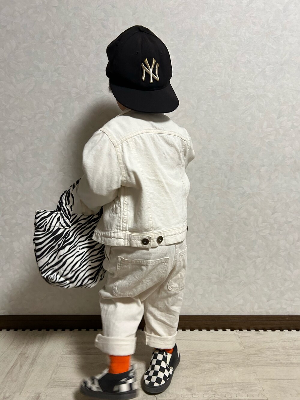 イエロー系のスウェット、ホワイト系のデニムジャケット、ホワイト系のサロペット/オーバーオールを着用したキッズの冬コーディネートの5枚目の写真