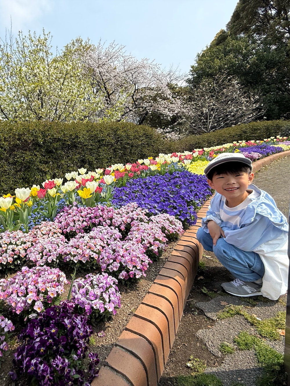 グリーン系のTシャツ/カットソー、ブルー系のナイロンジャケット、ブルー系のパンツを着用したキッズの春コーディネートの5枚目の写真