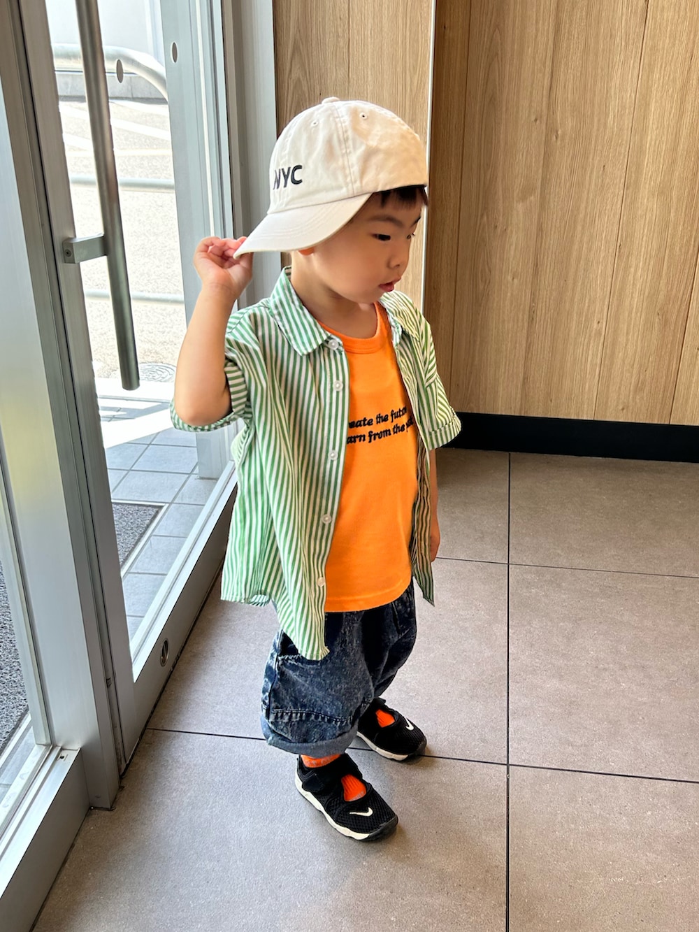 グリーン系のシャツ/ブラウス、オレンジ系のタンクトップ、ブルー系のデニムパンツを着用したキッズの夏コーディネートの2枚目の写真