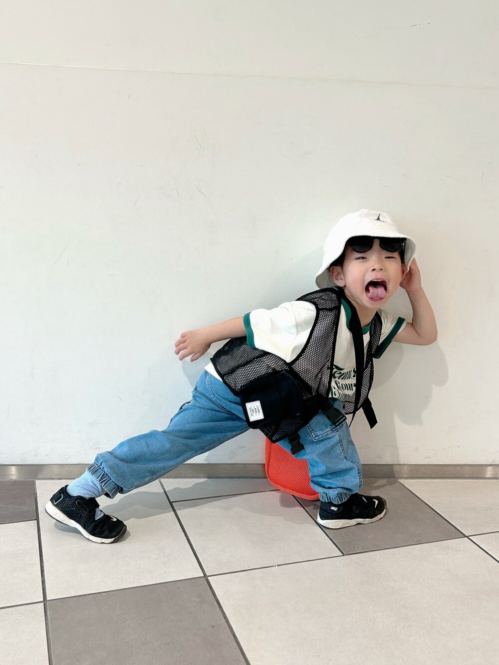 ホワイト系のTシャツ/カットソー、ブラック系のベスト、ブルー系のデニムパンツを着用したキッズの春コーディネートの3枚目の写真