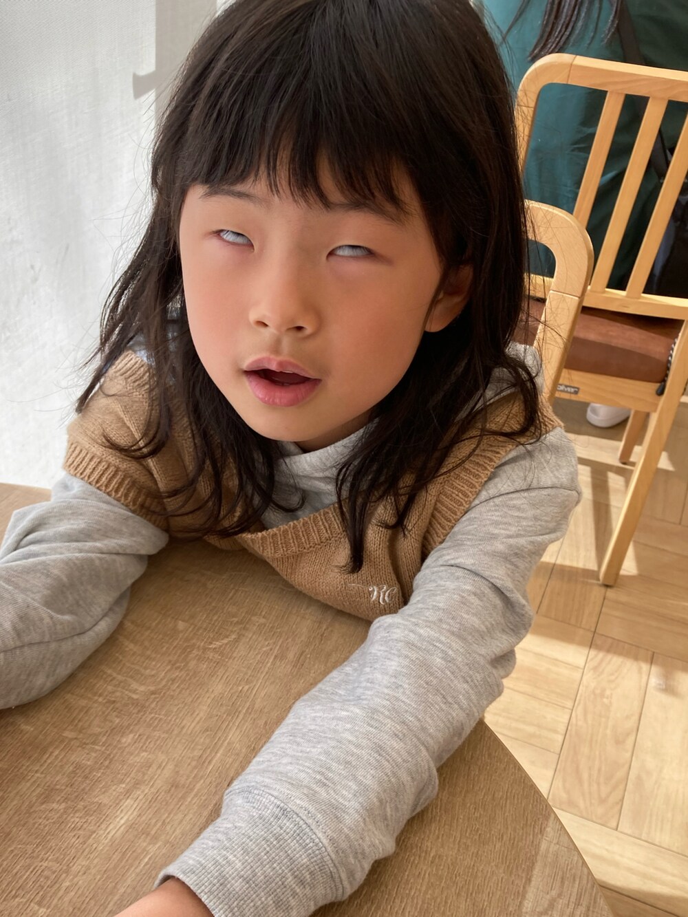 グレー系のワンピース、ベージュ系のベスト、ピンク系のショルダーバッグを着用したキッズの秋コーディネートの4枚目の写真