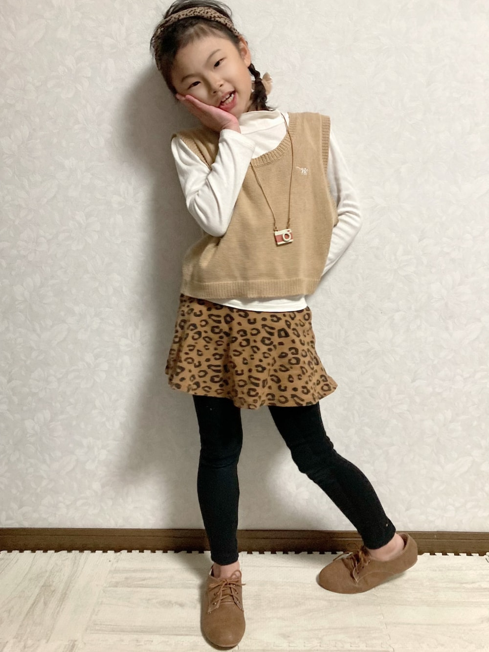 ホワイト系のTシャツ/カットソー、ベージュ系のベスト、ブラウン系のスカートを着用したキッズの秋コーディネートの4枚目の写真