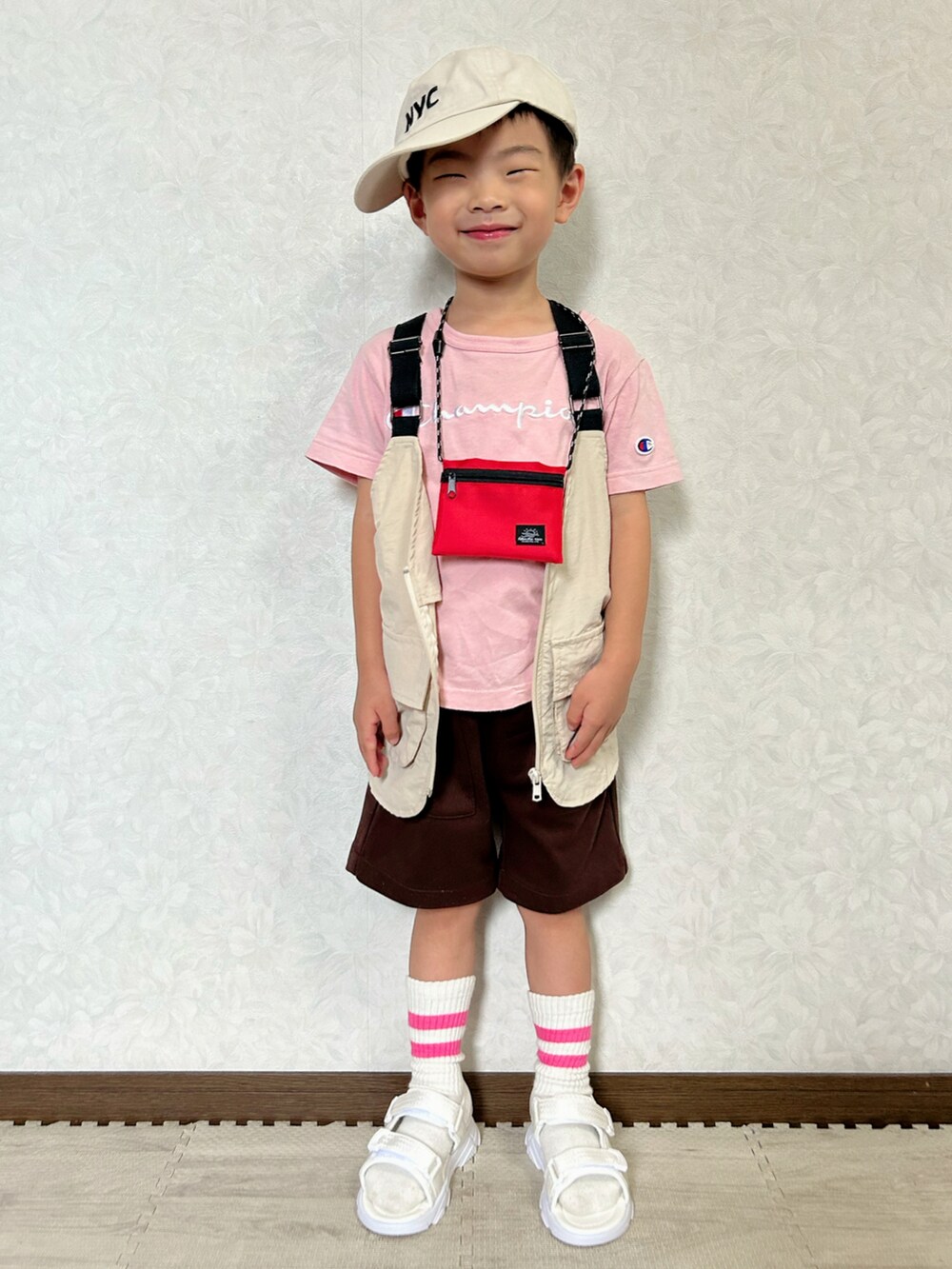 ピンク系のTシャツ/カットソー、ベージュ系のベスト、ブラウン系のパンツを着用したキッズの夏コーディネートの2枚目の写真