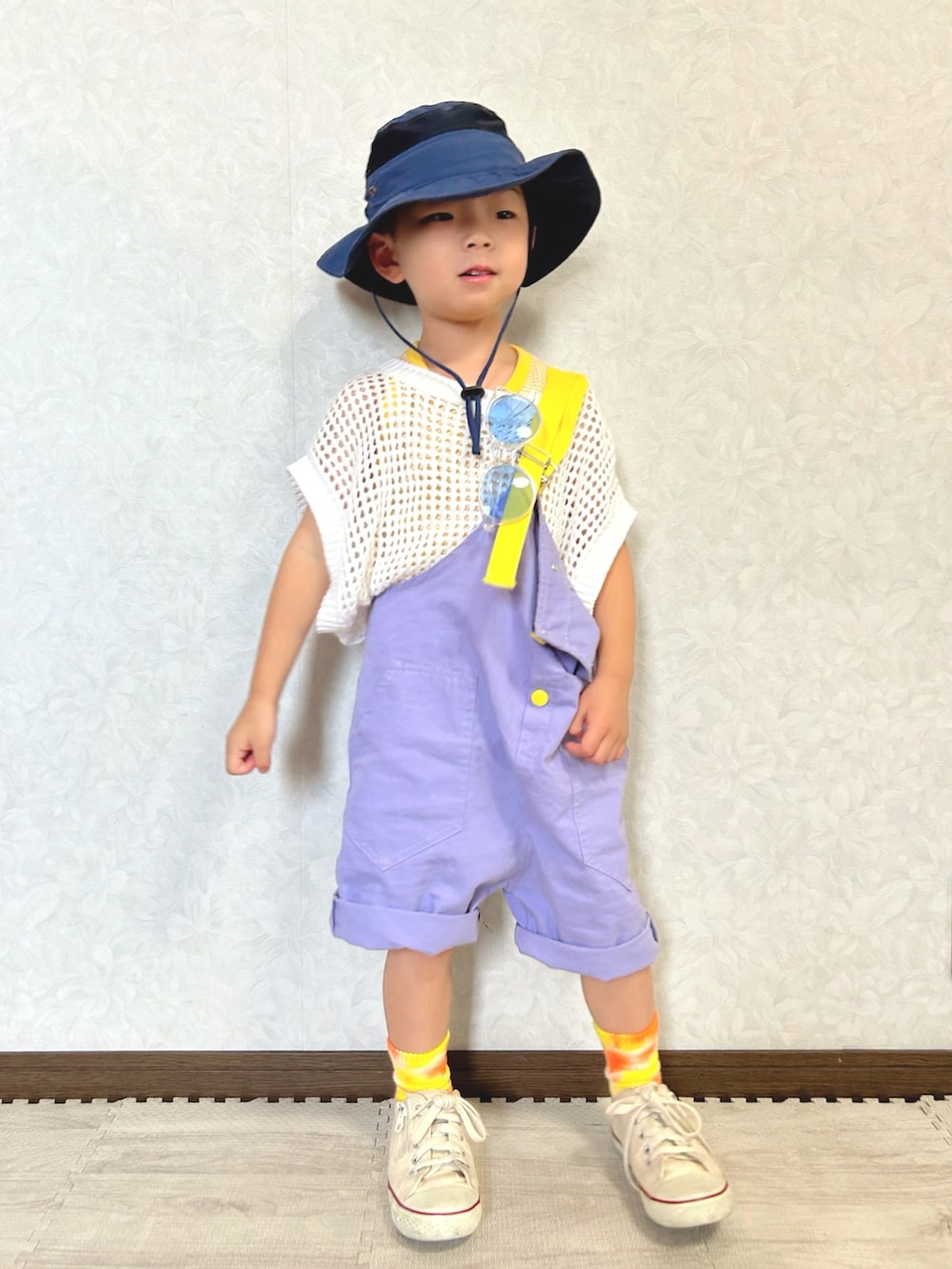 イエロー系のタンクトップ、ホワイト系のニット/セーター、パープル系のサロペット/オーバーオールを着用したキッズの夏コーディネートの5枚目の写真