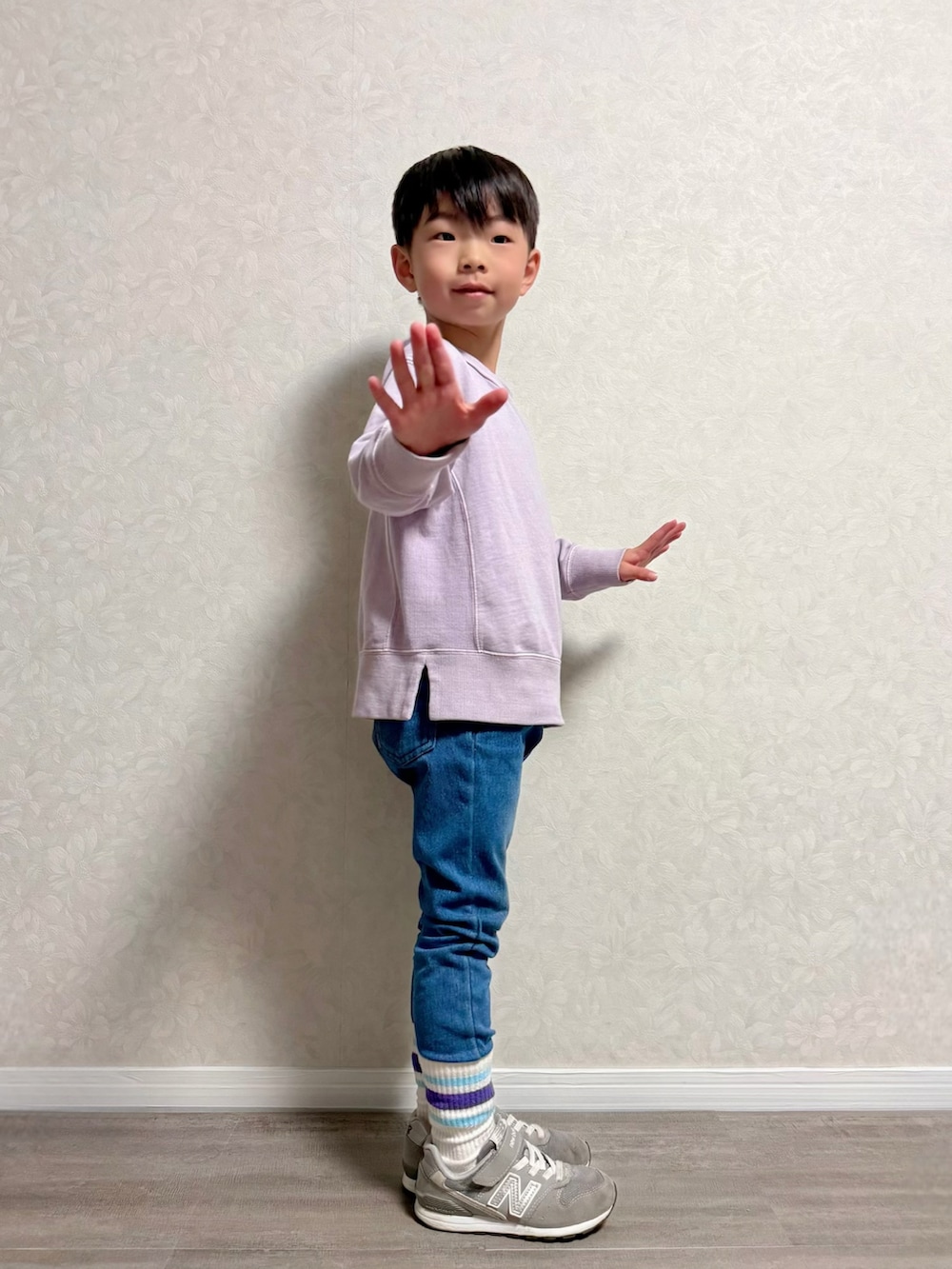 ブルー系のデニムパンツ、パープル系のスウェット、グレー系のスニーカーを着用したキッズの春コーディネートの4枚目の写真
