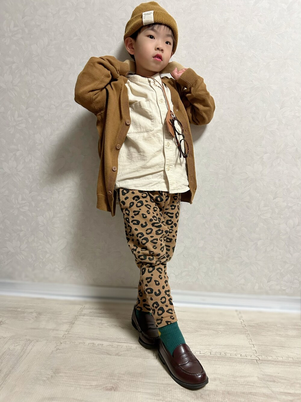 ブラウン系のカーディガン/ボレロ、ホワイト系のシャツ/ブラウス、ブラウン系のスウェットパンツを着用したキッズの秋コーディネートの3枚目の写真